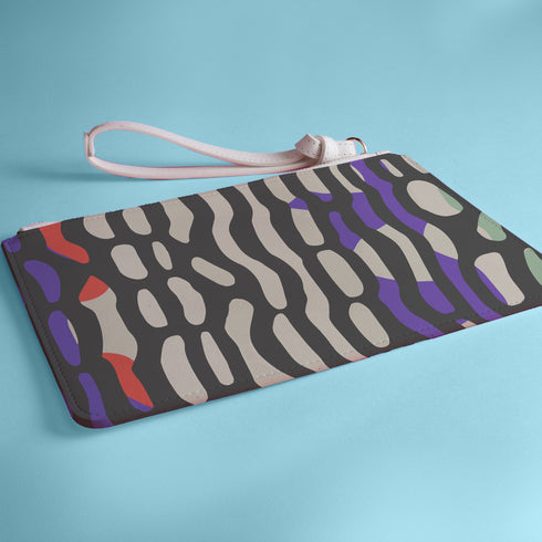 Rectangular wristlet clutch bag with psychedelic black, purple, red, and green pattern. White wrist strap and gold zipper visible